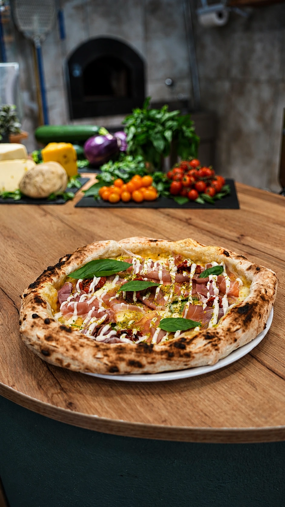 Pizza contemporanea con prosciutto crudo, pomodorini secchi e crema
